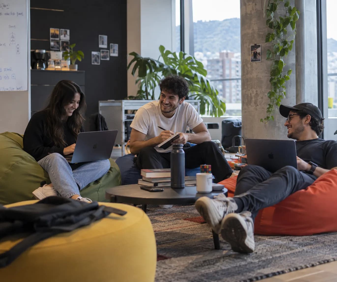 Dos integrantes del equipo conversan junto a una pared de trabajo